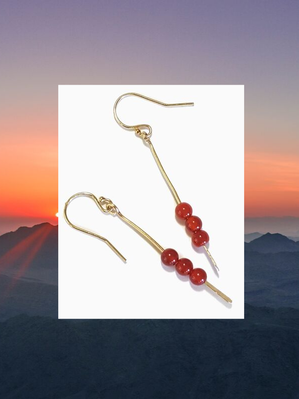 orange gemstone earrings and sunset backround